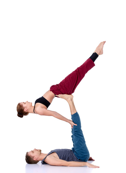 Young athletic couple practicing acroyoga. Balancing in pair - Foto, Bild
