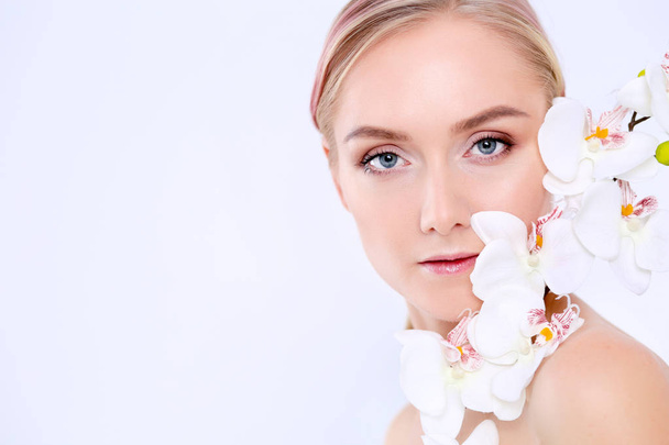 Young beauty woman with flower near face - Fotó, kép