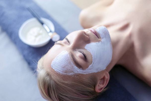 Face mask.Beautiful young girl at spa ,cosmetician woman applying facial mask - Foto, Imagem