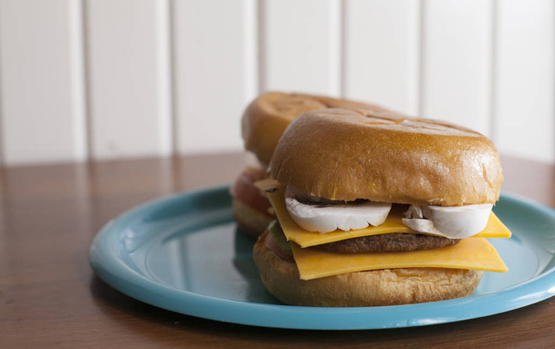 Un par de hamburguesas vegetarianas con queso en bollos dulces
 - Foto, imagen