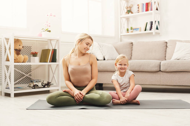 Happy mother and daughter having yoga training at home - Photo, Image