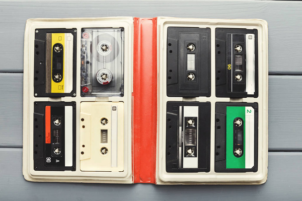 Cassetes de áudio vintage em organizador branco na mesa cinza, vista superior
 - Foto, Imagem