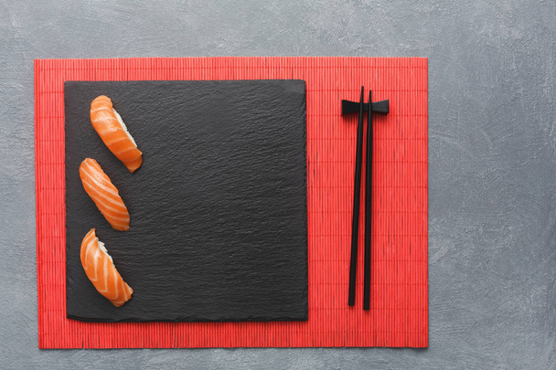 Ensemble de sushis et baguettes sur tapis rouge, vue de dessus
 - Photo, image