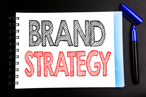 手書きの文字は、ブランド戦略を示します。鉛筆マーカーで書くマーケティング アイデア計画メモ帳メモ紙に書かれた、空間オフィス ビューと黒の背景のビジネス コンセプト - 写真・画像