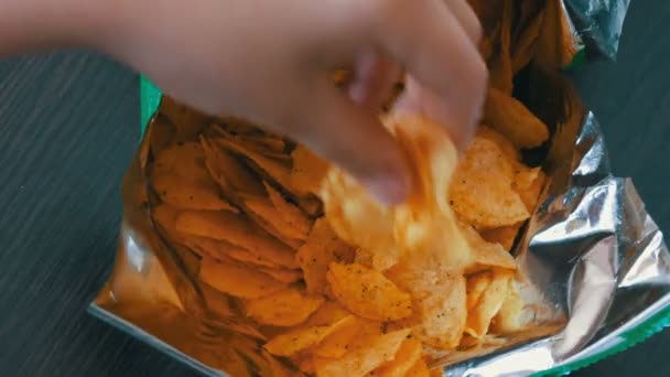 Adolescente toma con las manos las patatas fritas en paquetes
 - Imágenes, Vídeo