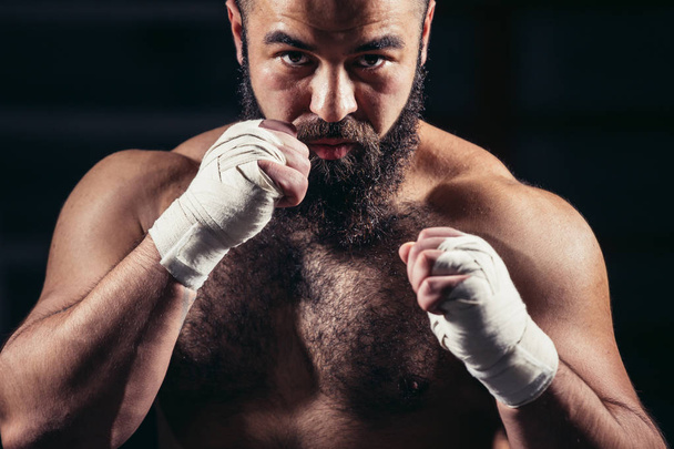 man boxing workout on ring. Caucasian male boxer in black gloves - Photo, image