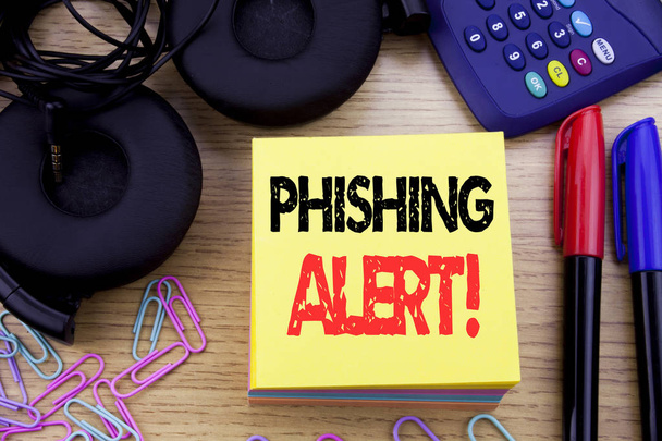 Parola, scrivendo Phishing Alert. Business concept for Fraud Warning Pericolo scritto su carta appiccicosa sullo sfondo in legno. Con calcolatrice e pennarello e cuffie
 - Foto, immagini