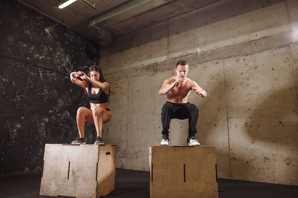 Homme et femme sautant sur la boîte en forme
 - Photo, image