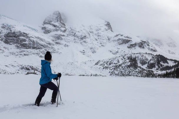 Abenteuerfrau wandert im Winter in der wunderschönen schneebedeckten Landschaft Kanadas. aufgenommen in joffre lake, nördlich von vancouver, britisch columbia, kanada. - Foto, Bild