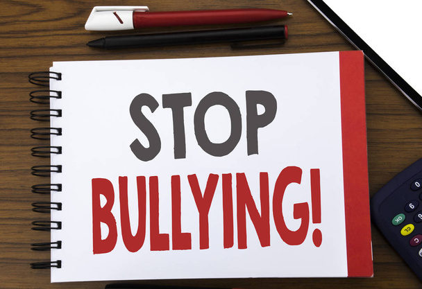 Handwritten text showing Stop Bullying. Business concept writing for Prevention Problem Bully Written on notepad note paper, wooden background in office view with pencil marker calculator - Photo, Image