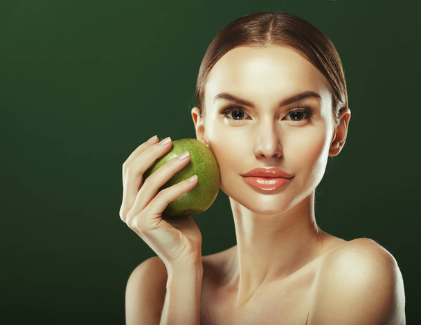 Young woman with  green apple over green background - Fotoğraf, Görsel