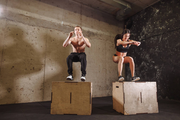 man and woman jumping on fit box - Φωτογραφία, εικόνα