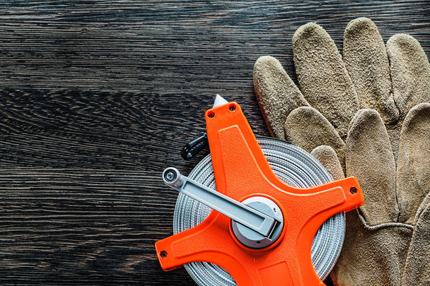 Measuring tape protective gloves on wooden board - 写真・画像