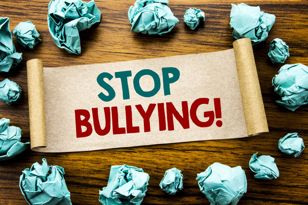 Слова, написание Stop Bullying. Бизнес-концепция для Prevention: Bully Warner на бумаге, на деревянном фоне со свернутой желтой бумагой, означающей мышление
 - Фото, изображение