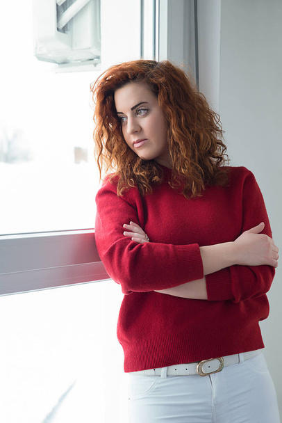 Red-haired girl by the window - Foto, immagini