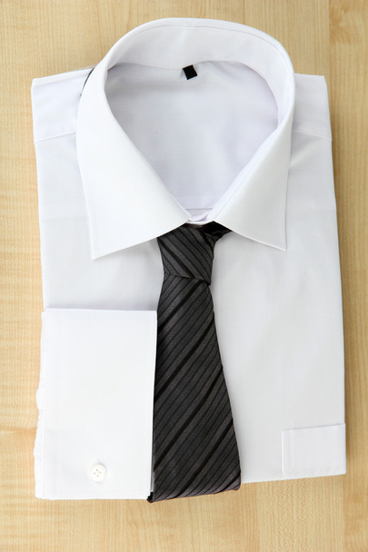New white man's shirt with color tie on wooden background - Foto, Imagem