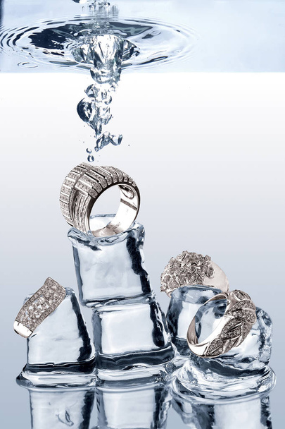 A view of jewelery being dropped on ice cubes underwater - Foto, Imagen