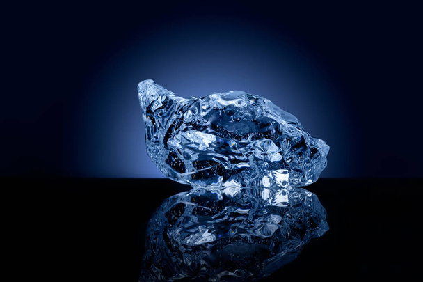 A professionally formed piece of ice on reflecting surface. - Zdjęcie, obraz