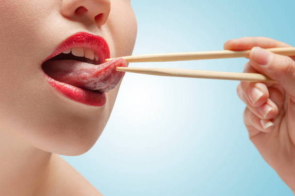 The photo of girl lower face with eating sticks hoding tongue. - Foto, Imagen