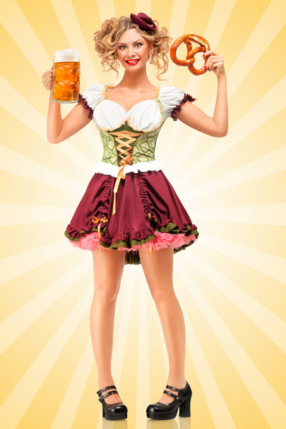Beautiful sexy Oktoberfest waitress wearing a traditional Bavarian dress dirndl holding a pretzel and beer mug, and smiling happily on colorful abstract cartoon style background. - Foto, imagen