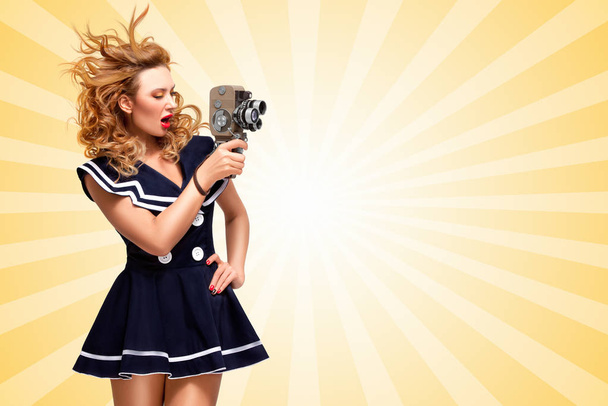 Pin-up sailor girl shooting a movie with an old cinema 8 mm camera on cartoon style background. - Foto, Imagen