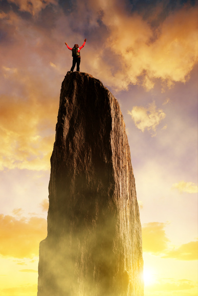 Альпинист на вершине скалы на закате
. - Фото, изображение