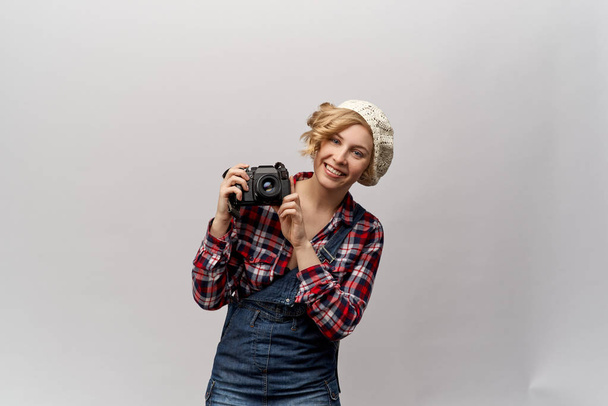 young attractive student girl traveler, dressed like a hipster smile. in front of her holding a retro camera.  - Foto, Imagem