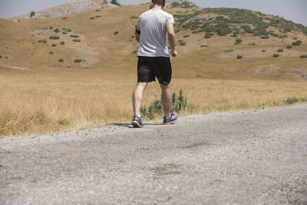 Чоловік біжить на горі під сонцем - концепція здорового способу життя
 - Фото, зображення