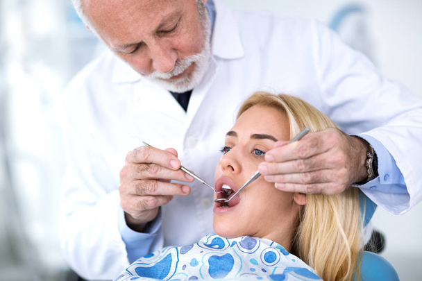 Senior dentist  reviews patient  teeth - Fotografie, Obrázek