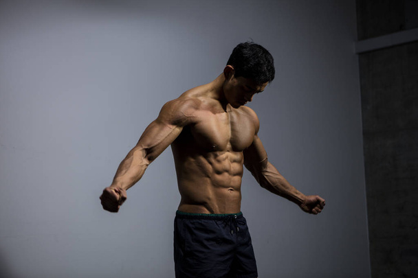Asian Fitness Model Flexing Muscles - Photo, Image