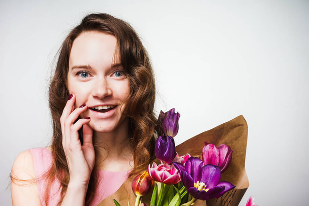 happy beautiful blue-eyed girl smiling, holding a big bouquet of flowers, celebrating the world women's day, March 8 - Foto, Imagem
