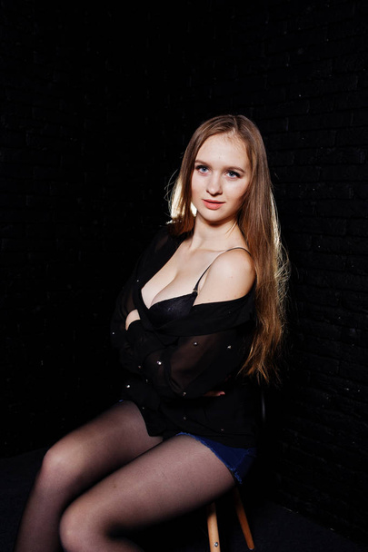 Studio shot of brunette girl in black blouse with bra and shorts - Foto, immagini