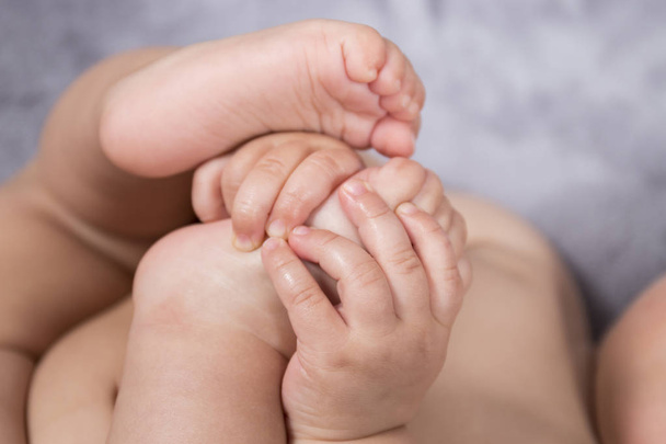 Zbliżenie ładny i małe dziecko stopy i dłonie. - Zdjęcie, obraz