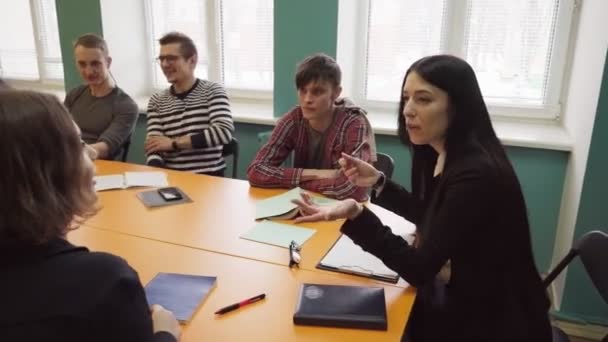 Tanár ül egy asztalnál, és beszél a diákok az egyetemen - Felvétel, videó
