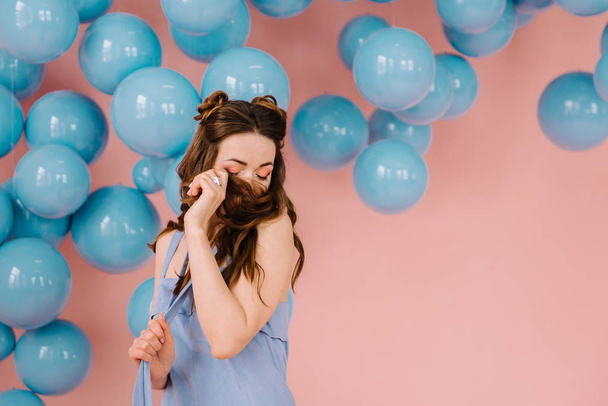 Egy pályázati lány, egy kék ruhát, egy rózsaszín teremben játszik egy kék borda - Fotó, kép