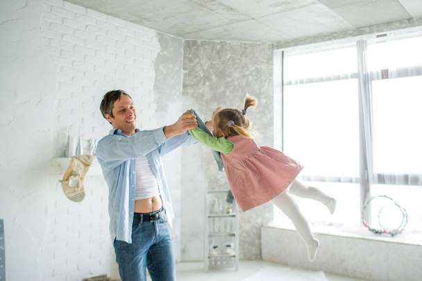 Отец играет с маленькой дочкой. Ребенок смеется от удовольствия
. - Фото, изображение