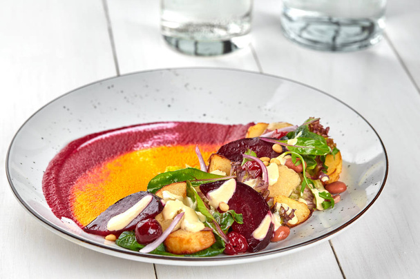 Zdravá strava: barevné červená řepa salát s bramborami a trhanými listy. Detailní záběr - Fotografie, Obrázek