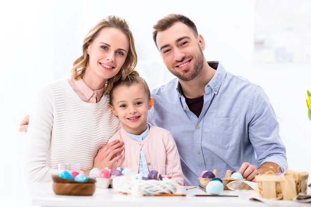 Cheerful family smiling by painted eggs for Easter - Valokuva, kuva