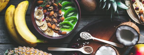 Yogurt with different fruits on a wooden background. Useful food, diet, organic. - Фото, зображення