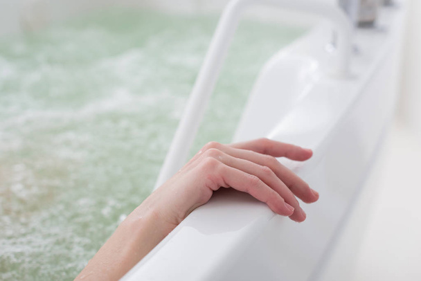 gedeeltelijke weergave van vrouw nemen van hidromassage bad in de spa salon - Foto, afbeelding