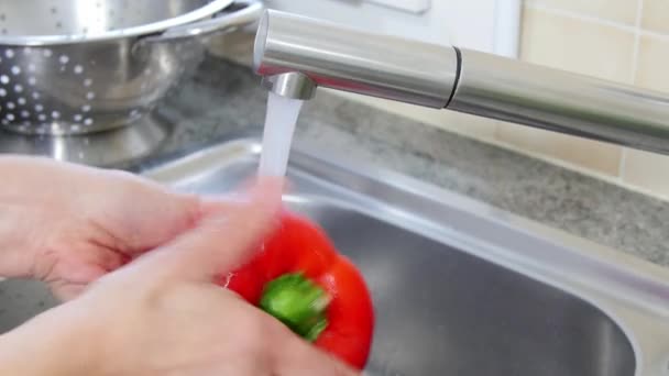 woman washing peppers in sink - Video