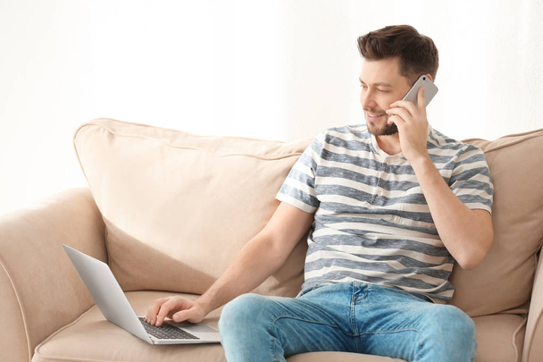 Jovem falando ao telefone enquanto trabalhava em casa
 - Foto, Imagem