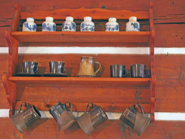 дерев'яні стелажі з гончарними виробами - ручна пофарбована чашка
 - Фото, зображення