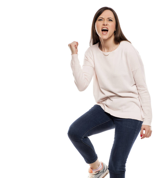 Young excited woman with winning gesture on a white background - Fotografie, Obrázek