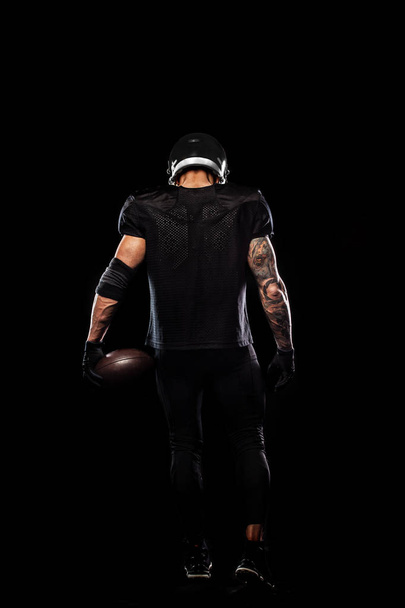 American football sportsman player isolated on black background - 写真・画像