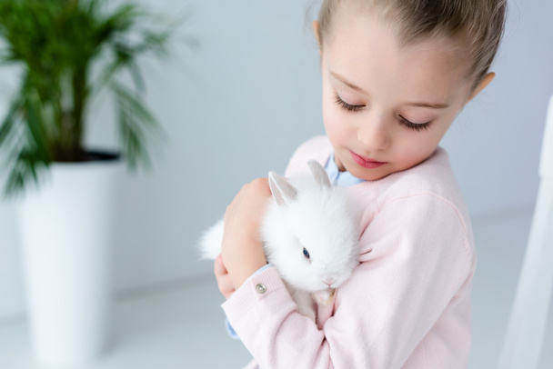  Child girl holding white rabbit - Фото, изображение