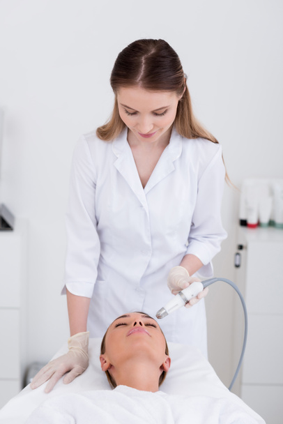 young woman getting facial treatment in cosmetology salon - Photo, Image