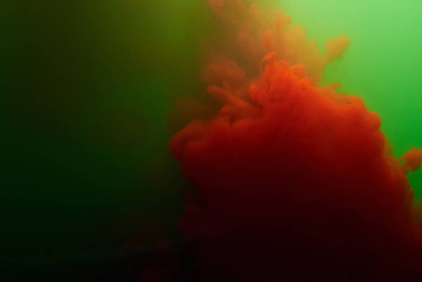 Punaisen musteen roiske vihreässä vedessä
 - Valokuva, kuva