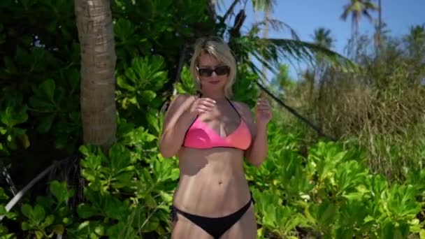 Young woman in pink swimwear at the beach - Footage, Video