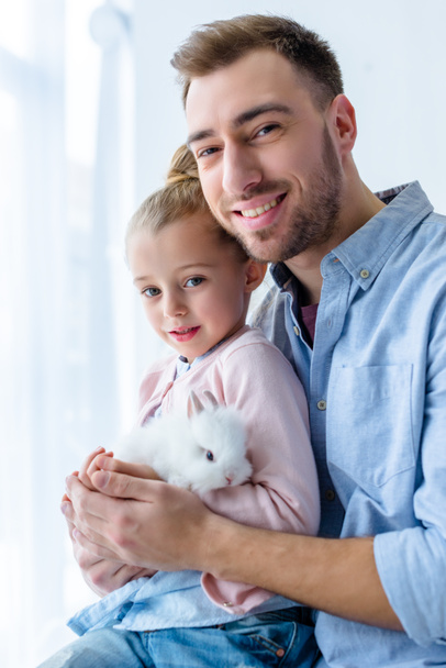 Ojciec i dziecko dziewczynka gospodarstwa biały króliczek - Zdjęcie, obraz
